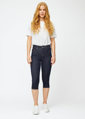 Ganzkörperbild eines Models in tief dunkelblauen Denim-Capris für Damen in der Farbe Midnights mit Skinny-Passform.