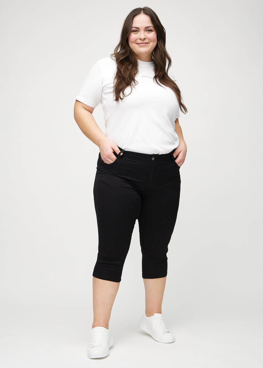 Skinny-Capris für Damen in schwarzem Jeansstoff, Farbe Ravens. Ganzkörperansicht eines Plus-Size-Models in den Capris.