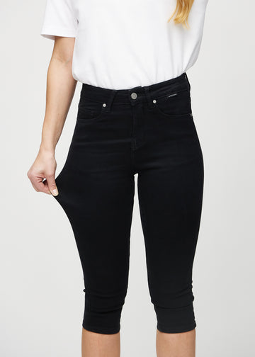 Skinny-Capris für Damen in schwarzem Jeansstoff, Farbe Ravens. Ein Model dehnt den Stoff, um den Stretch zu zeigen.