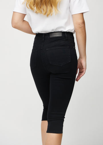 Skinny-Capris für Damen in schwarzem Jeansstoff, Farbe Ravens. Nahaufnahme von hinten an einem Model, zeigt Taschen und Nähte.