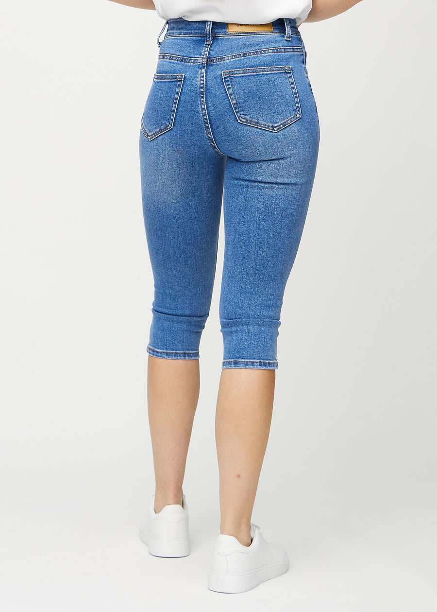 Skinny-Capris für Damen in blauem Denim, Farbe Rivers. Rückansicht an einem Model, zeigt die Passform und Gesäßtaschen.