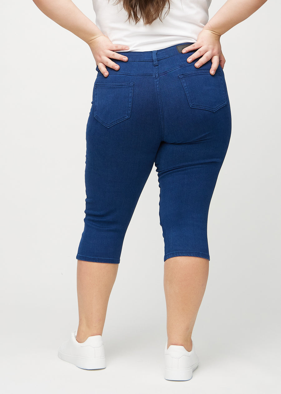 Dunkelblaue skinny Capris von hinten an einem Plus-Size-Model gesehen, sodass man das gesamte Produkt sehen kann.