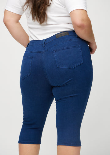 Dunkelblaue skinny Capris von hinten in Nahaufnahme an einem Plus-Size-Model, um Details zu zeigen.