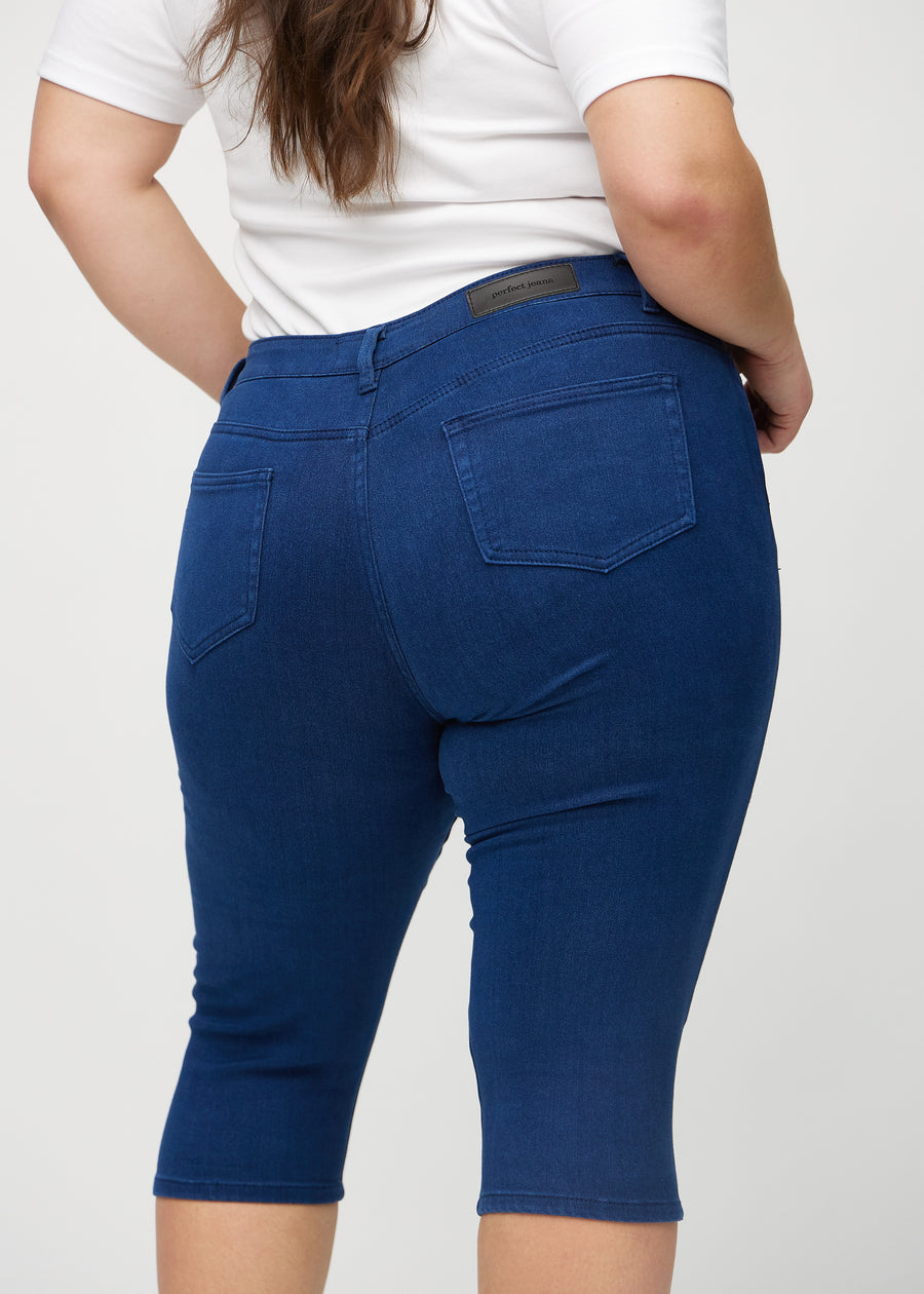 Dunkelblaue skinny Capris von hinten in Nahaufnahme an einem Plus-Size-Model, um Details zu zeigen.