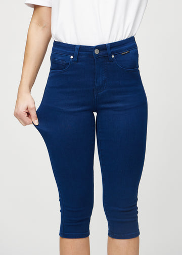 Das Model zieht die Capris am Oberschenkel auseinander, um den Stretch zu zeigen.