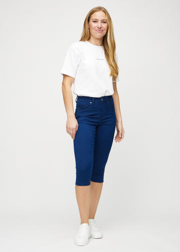 Ganzkörperbild eines Models in dunkelblauen skinny Capris.