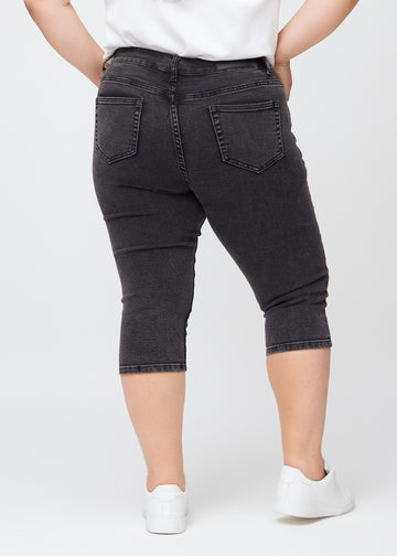 Skinny-Capris für Damen in dunkelgrauem Denim, Farbe Shadows. Rückansicht an einem Plus-Size-Model, zeigt die Passform und Gesäßtaschen.