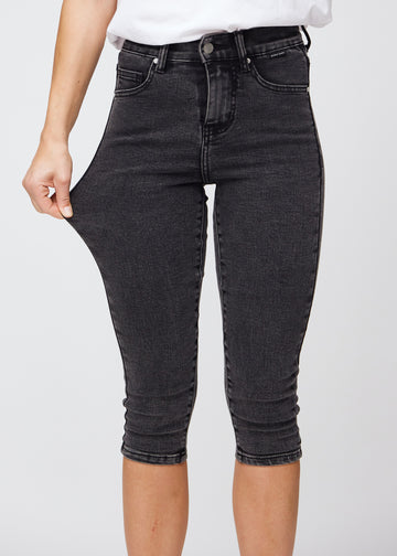 Skinny-Capris für Damen in dunkelgrauem Denim, Farbe Shadows. Ein Model dehnt den Stoff, um den Stretch zu zeigen.