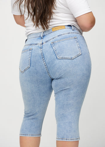 Hellblaue Denim-skinny-Capris von hinten in Nahaufnahme an einem Plus-Size-Model, um Details zu zeigen.