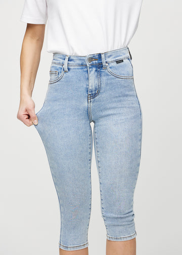Das Model zieht die Capris am Oberschenkel auseinander, um den Stretch zu zeigen.