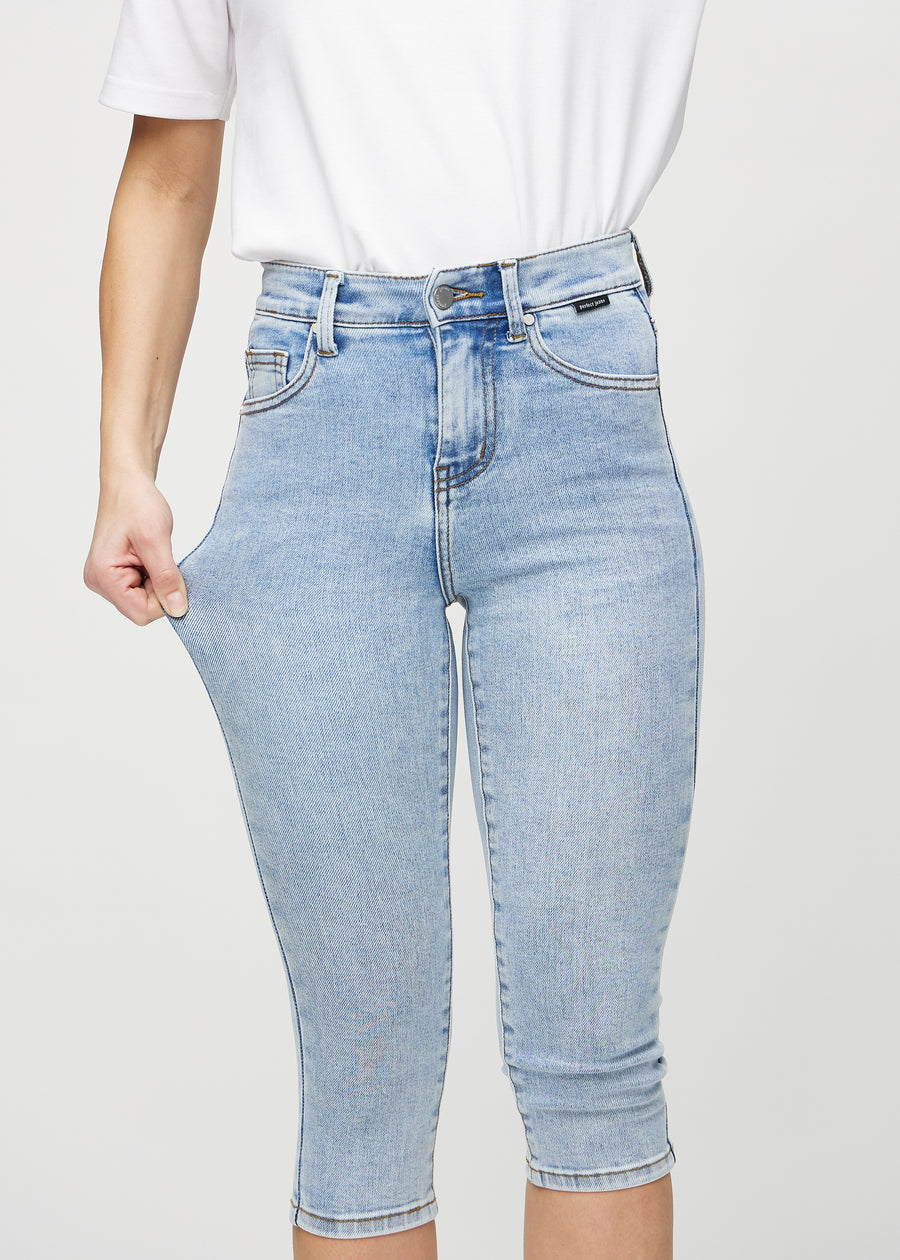 Das Model zieht die Capris am Oberschenkel auseinander, um den Stretch zu zeigen.