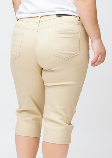 Slim-Capris für Damen aus beigefarbenem Jeansstoff, Farbe Gazelles. Nahaufnahme von hinten an einem Plus-Size-Model, zeigt Taschen und Nähte.
