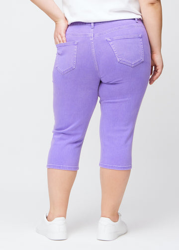 Slim-Capris für Damen aus pastellviolettem Jeansstoff, Farbe Lavenders. Rückansicht an einem Plus-Size-Model, zeigt Passform, Länge und Gesäßtaschen.