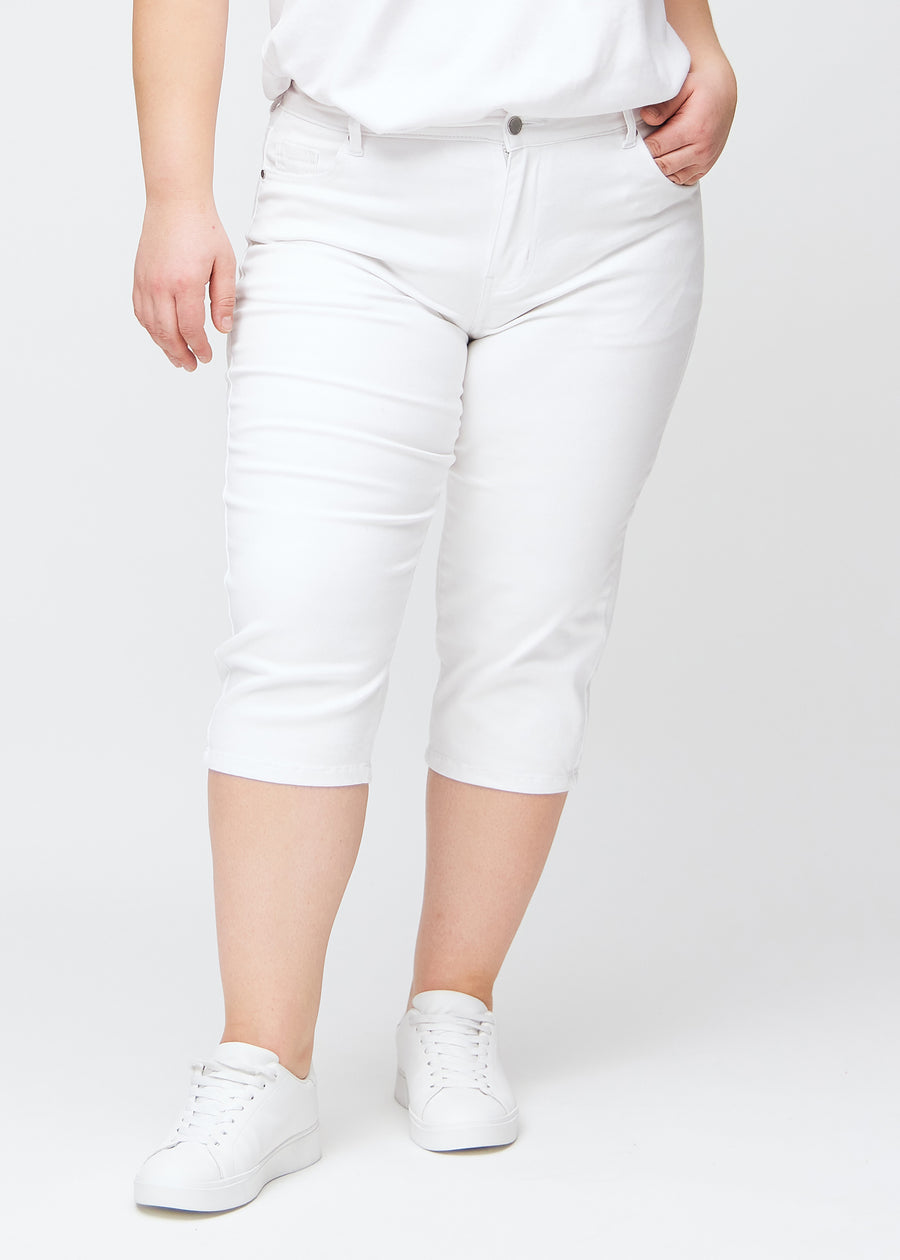 Slim-Capris für Damen aus weißem Jeansstoff, Farbe Marguerites. Vorderansicht an einem Plus-Size-Model, figurbetonter Schnitt bis knapp unter das Knie.