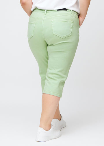 Slim-Capris für Damen aus pastellhellgrünem Jeansstoff, Farbe Mints. Rückansicht an einem Plus-Size-Model, zeigt Passform, Länge und Gesäßtaschen.
