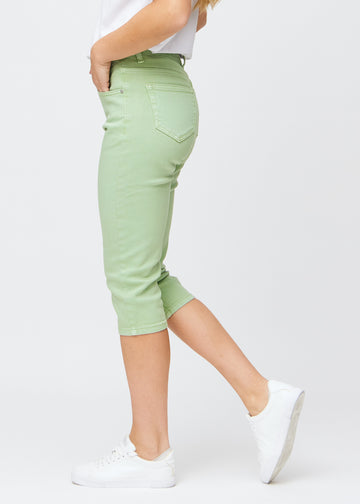Slim-Capris für Damen aus pastellhellgrünem Jeansstoff, Farbe Mints. Seitenansicht an einem Model, figurbetonter Schnitt und mittelhoher Bund (Mid Rise).