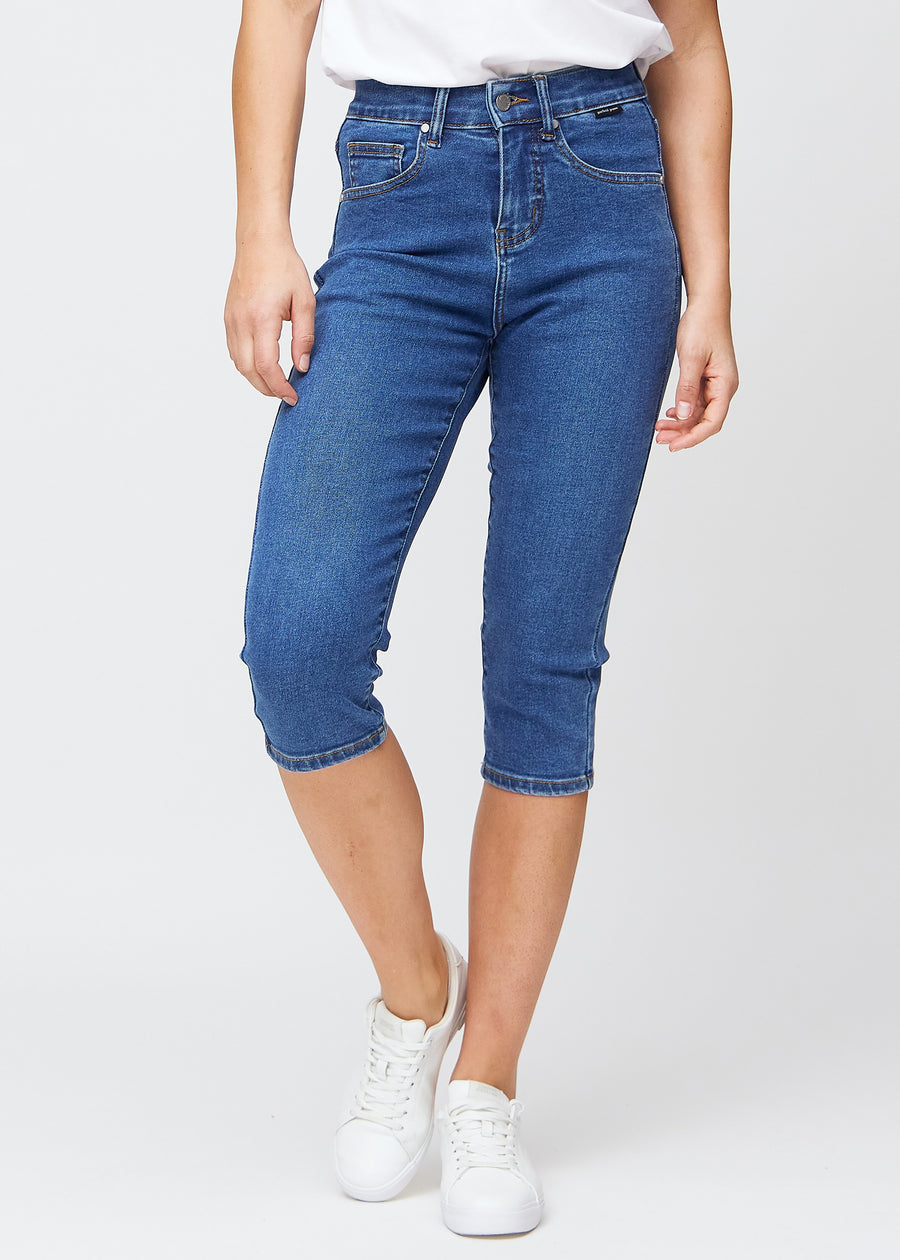 Dunkelblaue Denim-slim-Capris, Farbe Oceans, mit enger Passform, die die Beine formt und direkt unter dem Knie endet, von vorne gesehen.