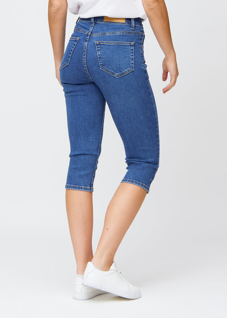 Dunkelblaue Denim-slim-Capris von hinten gesehen, das gesamte Produkt wird am Model mit Fokus auf Passform und Länge gezeigt.