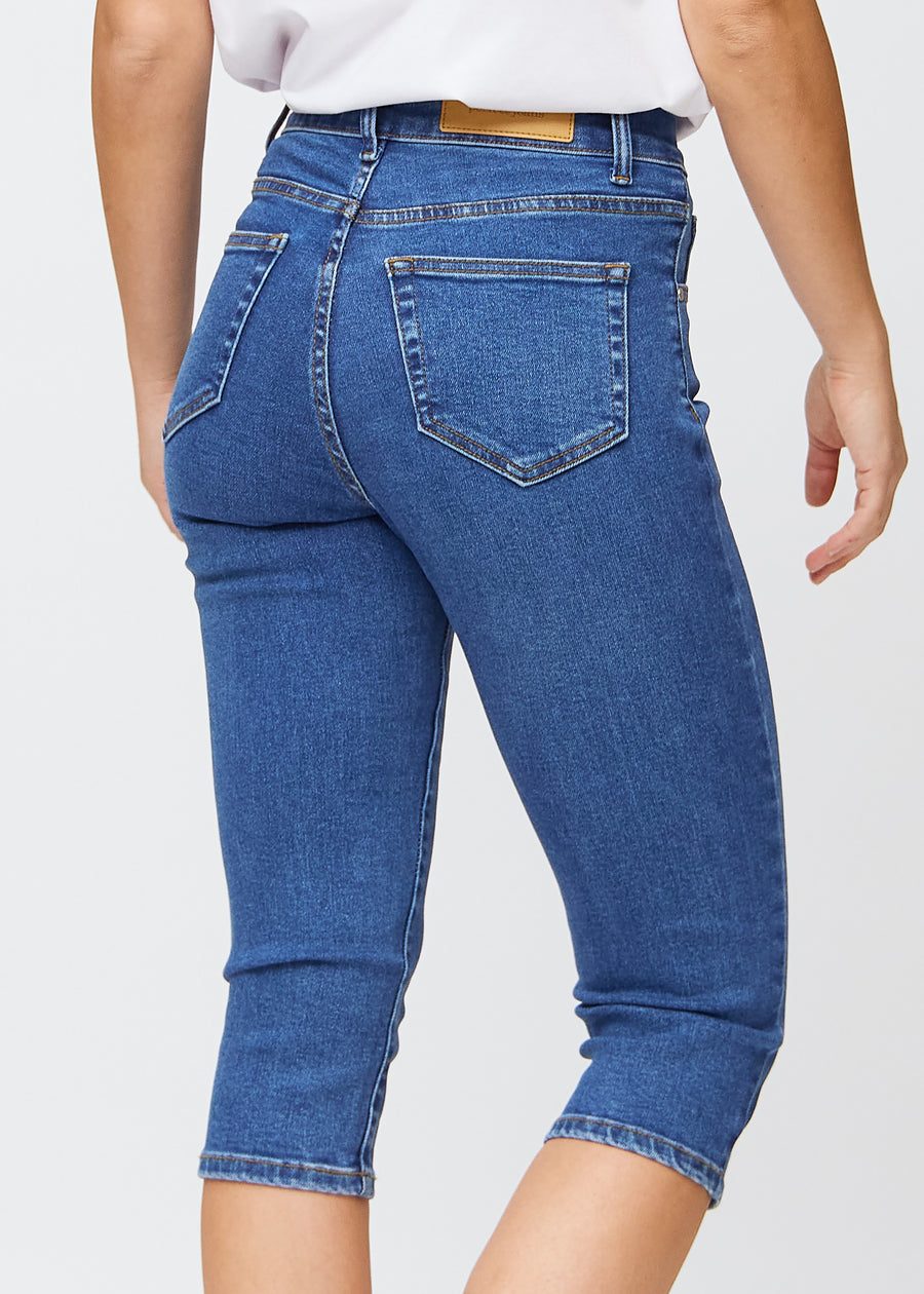 Nahaufnahme der dunkelblauen Denim-slim-Capris von hinten, sodass Details und Taschen deutlich zu sehen sind.
