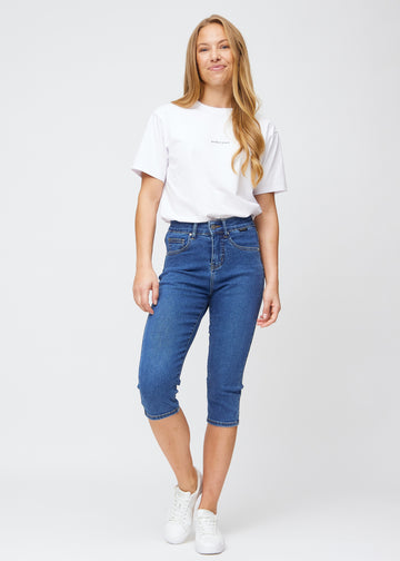 Ganzkörperbild eines Models in dunkelblauen Denim-slim-Capris.