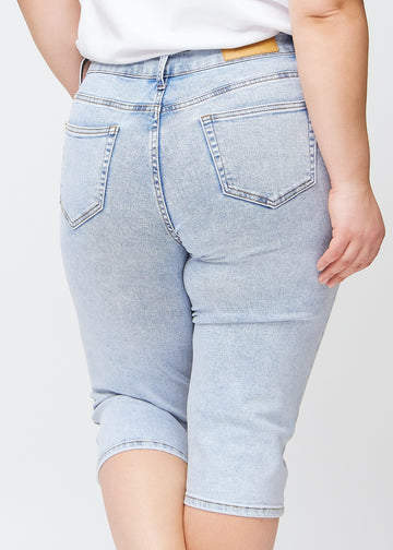 Slim-Capris für Damen aus hellblauem Denim, Farbe Waves. Nahaufnahme von hinten an einem Plus-Size-Model, zeigt Taschen und Nähte.