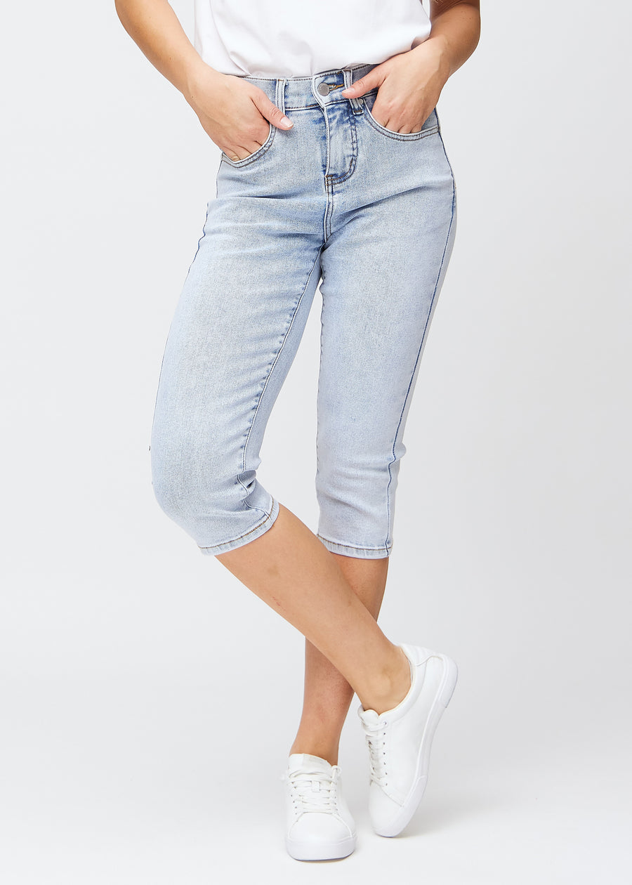 Slim-Capris für Damen aus hellblauem Denim, Farbe Waves. Vorderansicht an einem Model, figurbetonter Schnitt bis knapp unter das Knie.