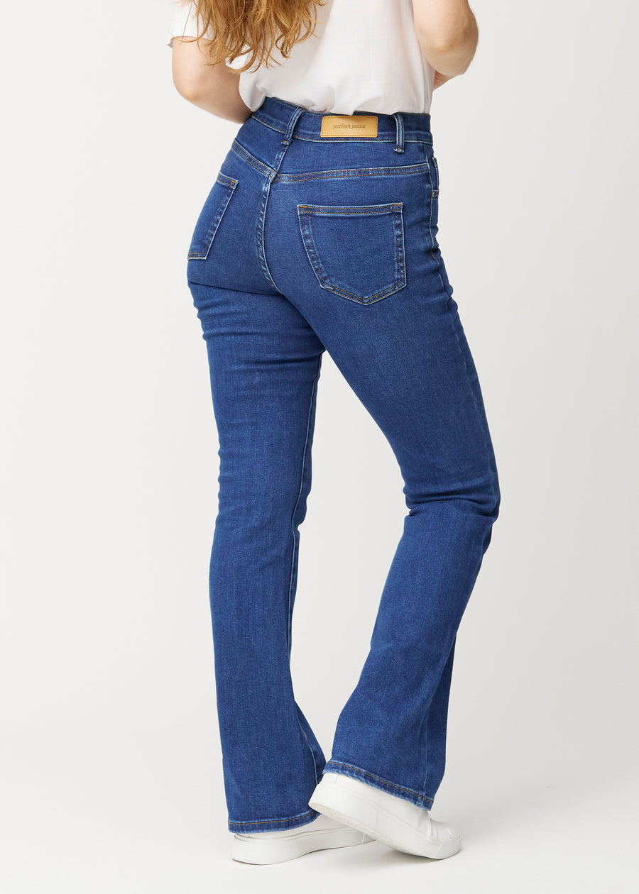 Dunkelblaue Mid-Rise-Bootcut-Jeans in der Farbe Oceans. Rückansicht an einem Model, die gesamte Passform ist zu sehen.