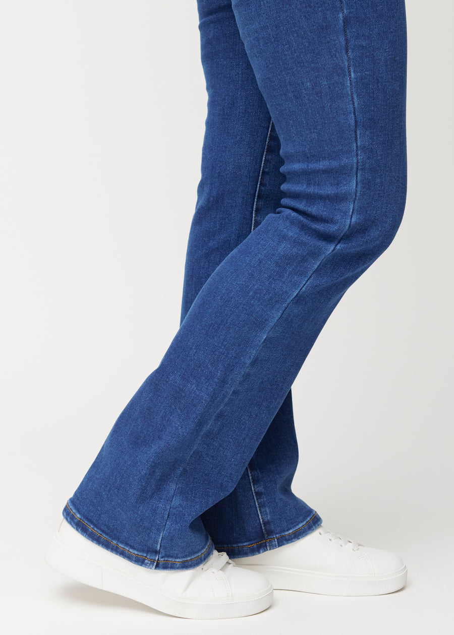 Dunkelblaue Mid-Rise-Bootcut-Jeans in der Farbe Oceans. Nahaufnahme am Knöchel eines Model, um den leichten Schlag am Beinabschluss zu zeigen.