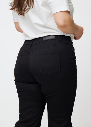 Schwarze Mid-Rise-Bootcut-Jeans in der Farbe Ravens. Nahaufnahme der Rückseite an einem Plus-Size-Model, um Details zu zeigen.