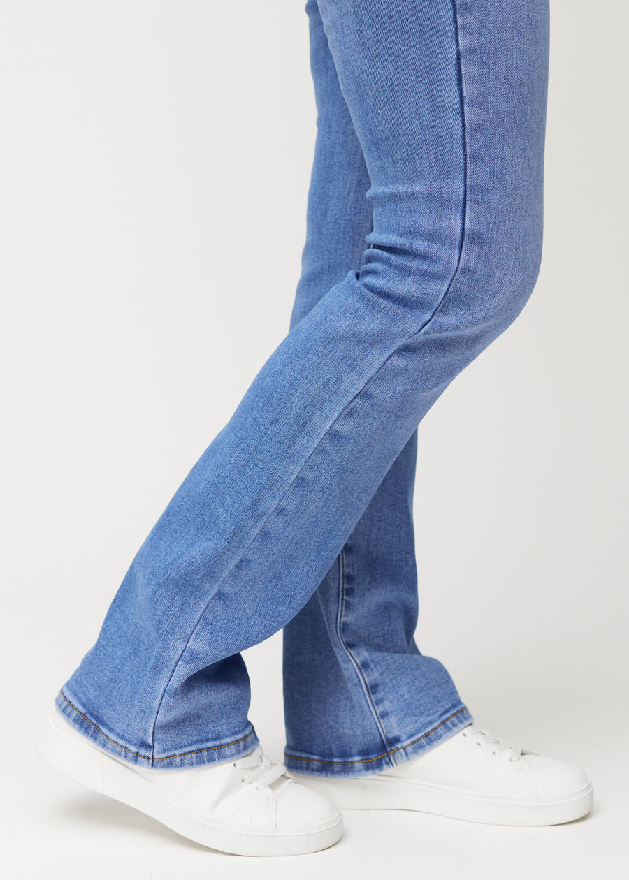 Blaue Mid-Rise-Bootcut-Jeans in der Farbe Rivers. Nahaufnahme am Knöchel eines Model, um den leichten Schlag am Beinabschluss zu zeigen.