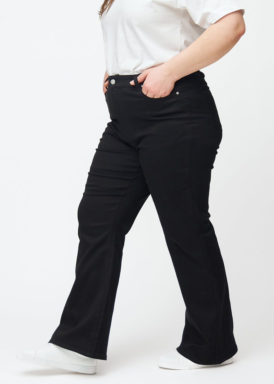 Schwarze hochtaillierte Bootcut jeans seitlich an einem Plus-Size-Model gesehen.