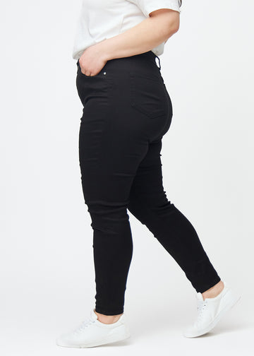 Schwarze Plus-Size-High-Rise-skinny jeans für Damen in der Farbe Ravens sind seitlich an einem Model zu sehen.