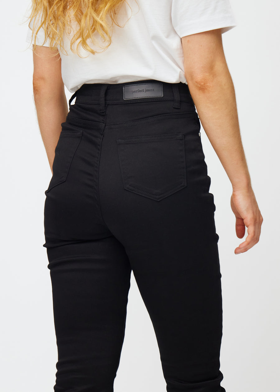 Schwarze hochtaillierte slim jeans von hinten in Nahaufnahme, um Details zu zeigen.