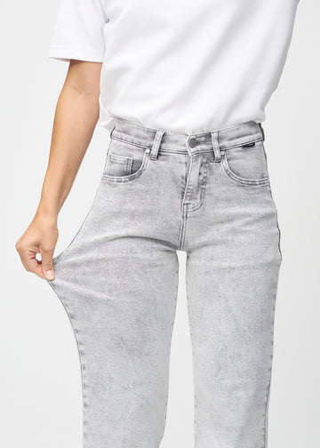 Loose-Jeans für Damen in Hellgrau, Farbe Ashes. Ein Model dehnt den Jeansstoff am Oberschenkel, um den Stretch zu zeigen.
