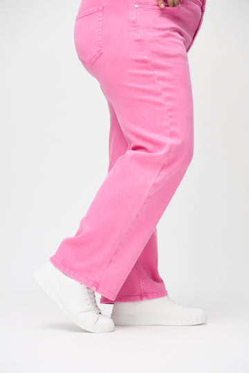 Loose-Jeans für Damen in Hellrosa, Farbe Flamingos. Nahaufnahme an den Knöcheln eines Plus-Size-Models, um die weiten Beinabschlüsse zu zeigen.