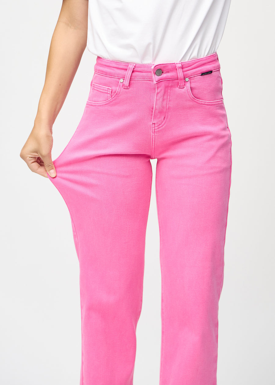 Loose-Jeans für Damen in Hellrosa, Farbe Flamingos. Ein Model dehnt den Jeansstoff am Oberschenkel, um den Stretch zu zeigen.