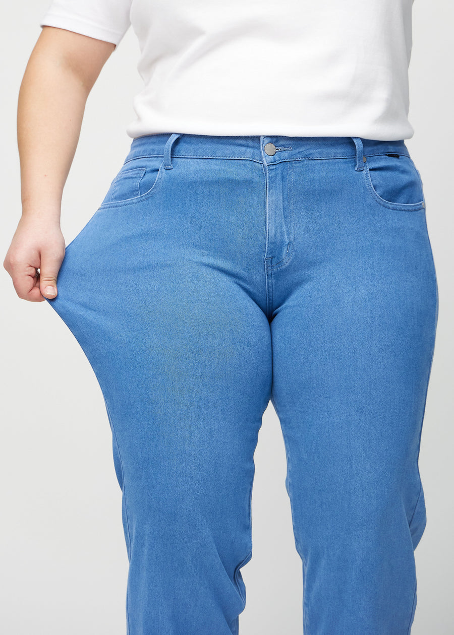 Loose-Jeans für Damen in Blau, Farbe Geraniums. Ein Plus-Size-Model dehnt den Jeansstoff am Oberschenkel, um den Stretch zu zeigen.
