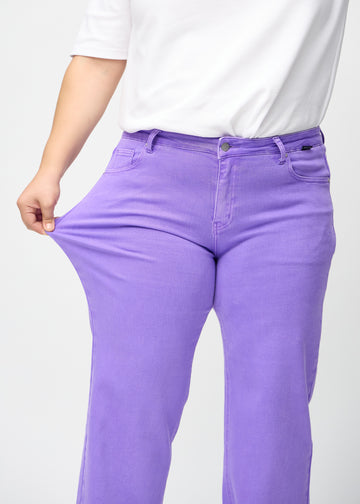 Loose-Jeans für Damen in Lila, Farbe Lavenders. Ein Plus-Size-Model dehnt den Jeansstoff am Oberschenkel, um den Stretch zu zeigen.