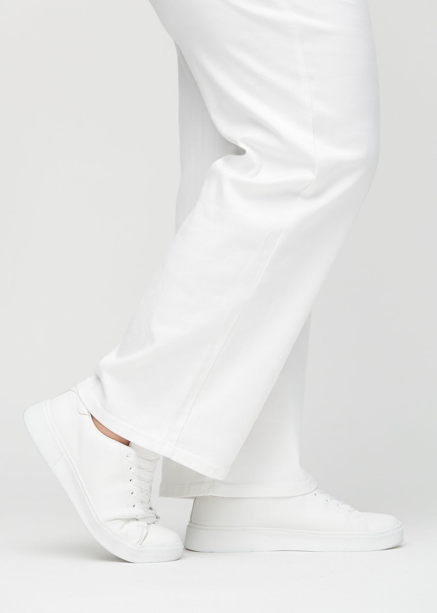 Loose-Jeans für Damen in Weiß, Farbe Marguerites. Nahaufnahme an den Knöcheln eines Plus-Size-Models, um die weiten Beinabschlüsse zu zeigen.