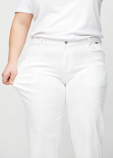Loose-Jeans für Damen in Weiß, Farbe Marguerites. Ein Plus-Size-Model dehnt den Jeansstoff am Oberschenkel, um den Stretch zu zeigen.
