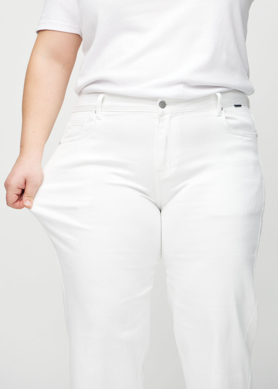 Loose-Jeans für Damen in Weiß, Farbe Marguerites. Ein Plus-Size-Model dehnt den Jeansstoff am Oberschenkel, um den Stretch zu zeigen.