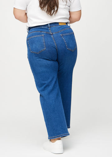 Loose-Jeans für Damen in Dunkelblau, Farbe Oceans. Rückansicht an einem Plus-Size-Model, die gesamte lockere Passform ist zu sehen.