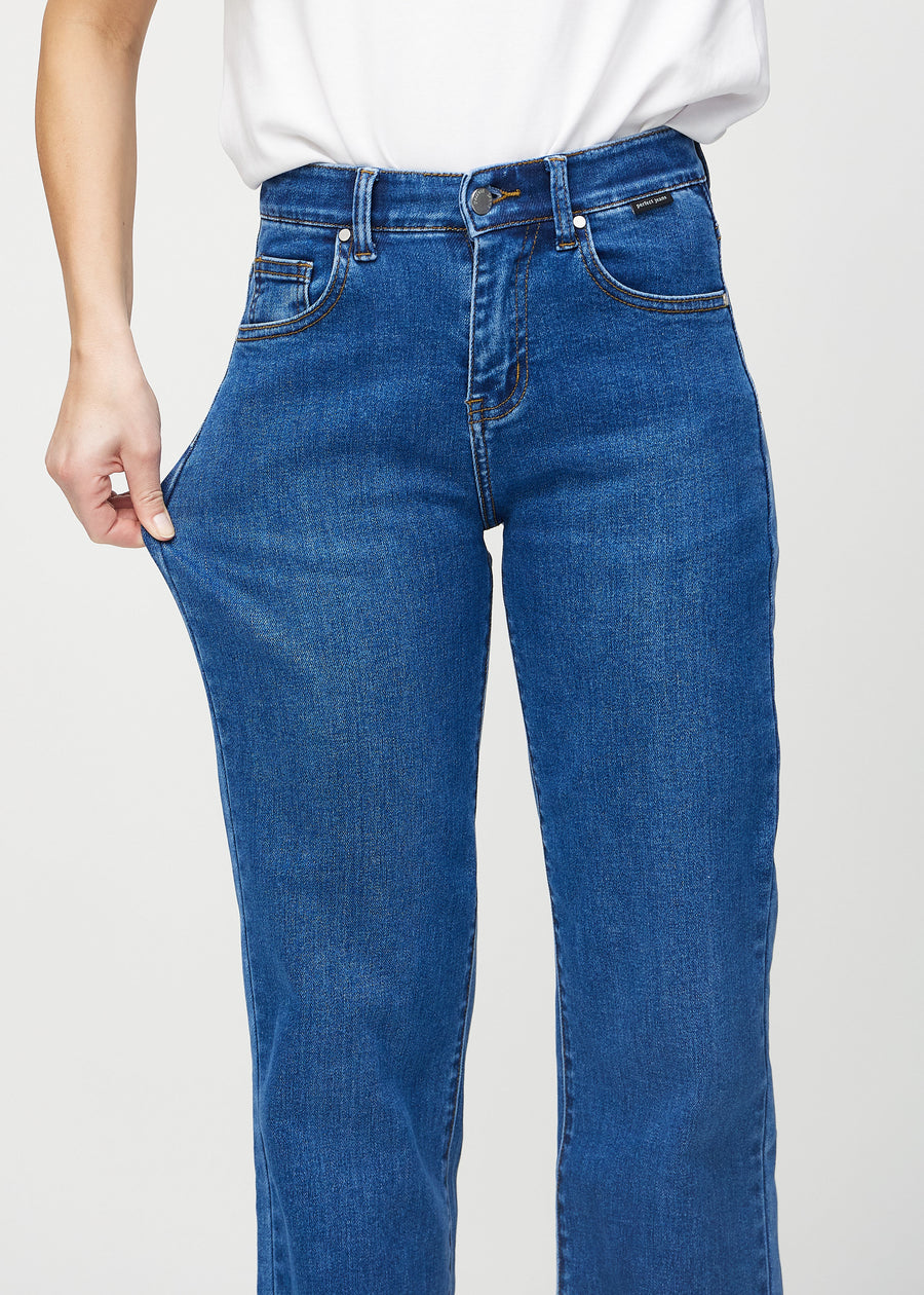 Loose-Jeans für Damen in Dunkelblau, Farbe Oceans. Ein Model dehnt den Jeansstoff am Oberschenkel, um den Stretch zu zeigen.