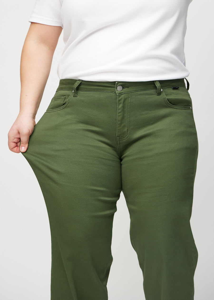 Loose-Jeans für Damen in Dunkelgrün, Farbe Renewals. Ein Plus-Size-Model dehnt den Jeansstoff am Oberschenkel, um den Stretch zu zeigen.