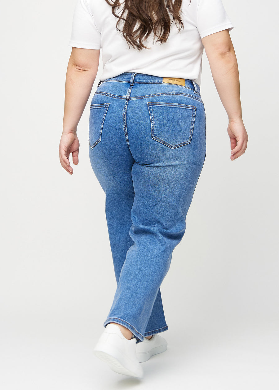 Denim loose jeans von hinten an einem Plus-Size-Model gesehen, damit man das gesamte Produkt sehen kann.
