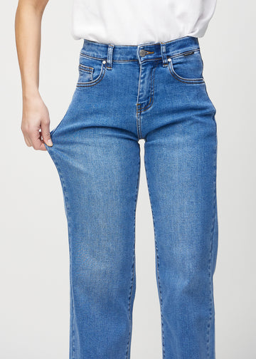 Das Model zieht die Jeans am Oberschenkel, um den Stretch zu zeigen.