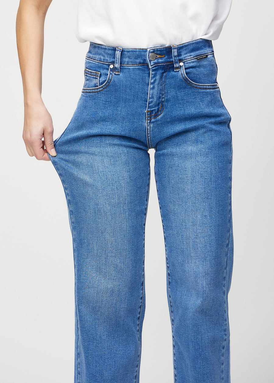 Das Model zieht die Jeans am Oberschenkel, um den Stretch zu zeigen.