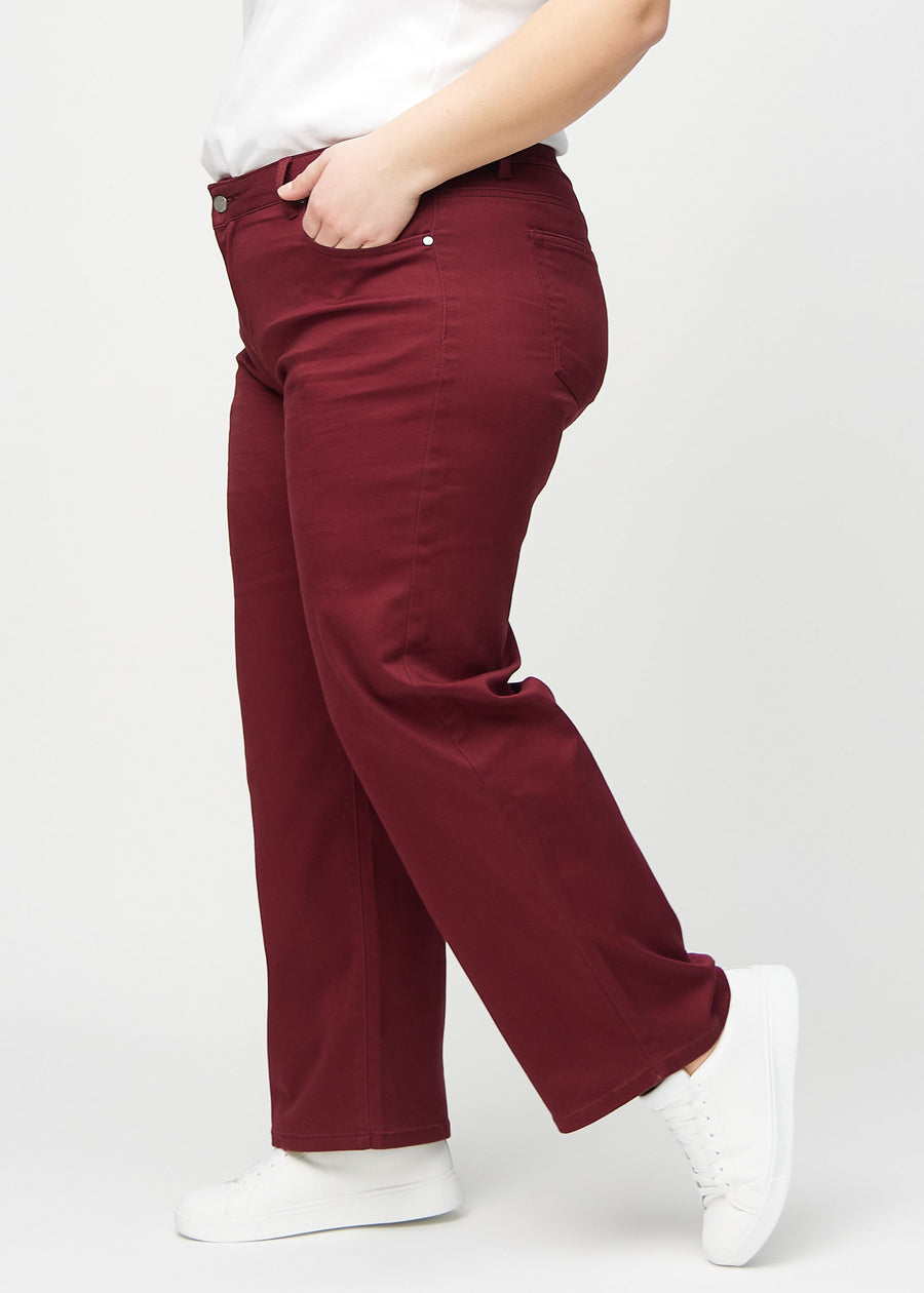 Loose-Jeans für Damen in Dunkelrot, Farbe Santas. Seitenansicht an einem Plus-Size-Model, die weite Passform ist zu sehen.