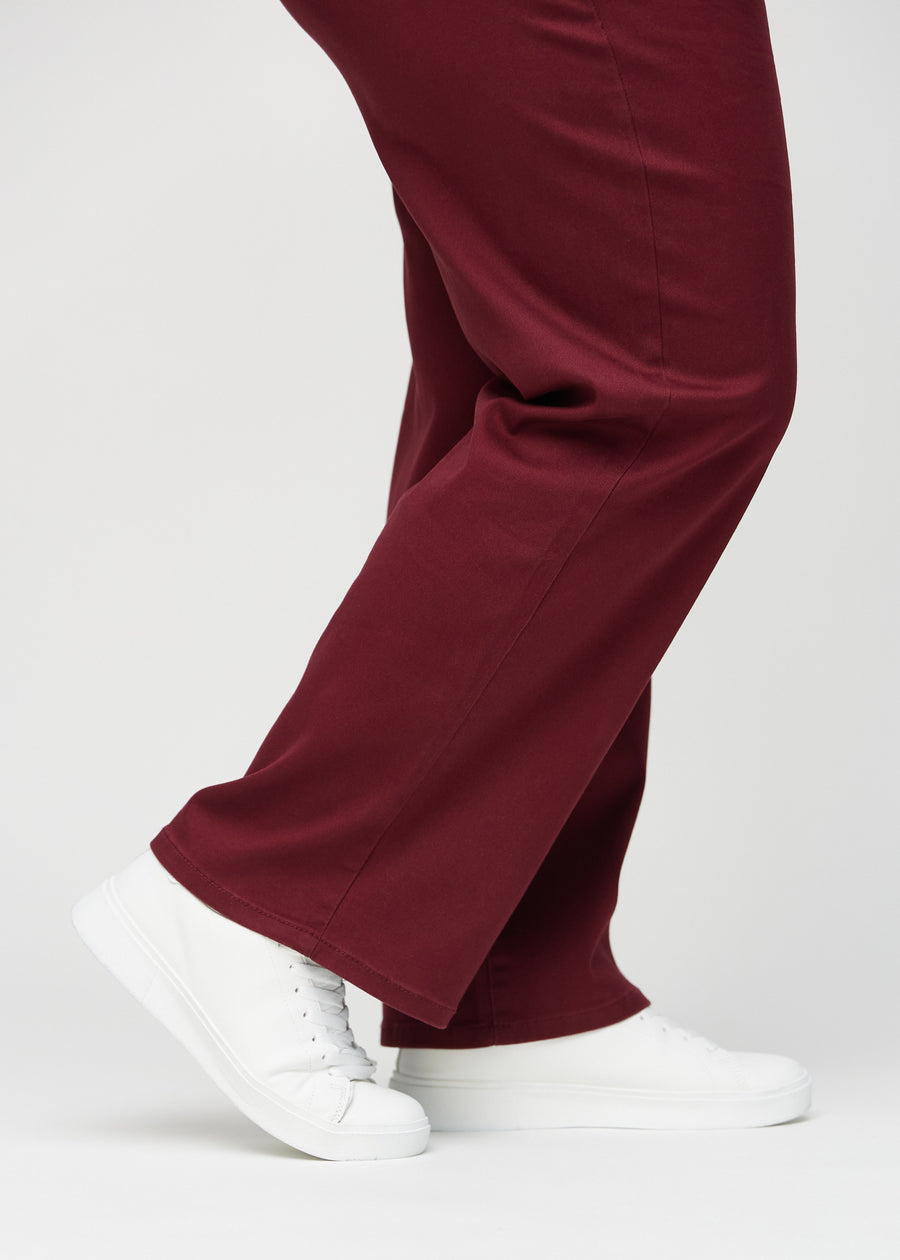Loose-Jeans für Damen in Dunkelrot, Farbe Santas. Nahaufnahme an den Knöcheln eines Plus-Size-Models, um die weiten Beinabschlüsse zu zeigen.