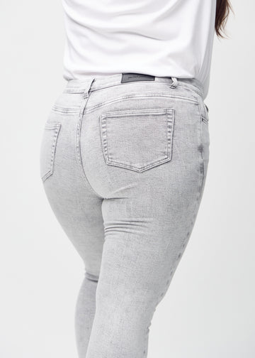 Hellgrauer Denim skinny jeans von hinten aus der Nähe an einem Plus-Size-Model gezeigt, um Details zu zeigen.